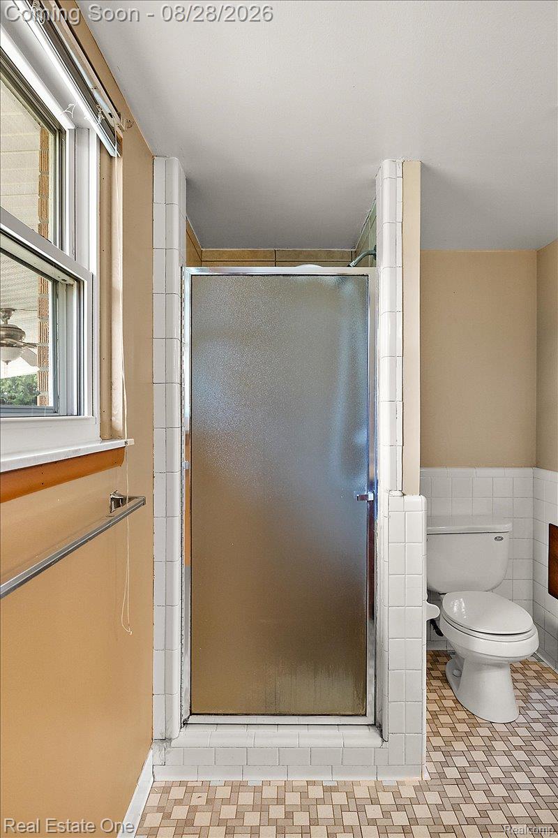 15250 34 Mile Road Armada, MI 48005 - Photo 43 of 49 Frosted glass shower enclosure, white ceramic tile shower surround, patterned tile flooring, and a white toilet