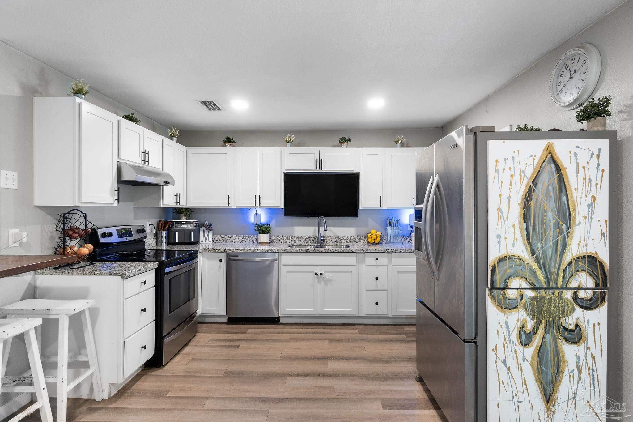 10610 Chemstrand Road Pensacola, FL 32514 - Photo 11 of 42 a kitchen with stainless steel appliances a stove top oven a refrigerator a sink and dishwasher