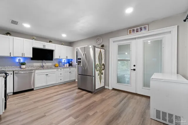 a kitchen with a refrigerator stove and wooden floor
