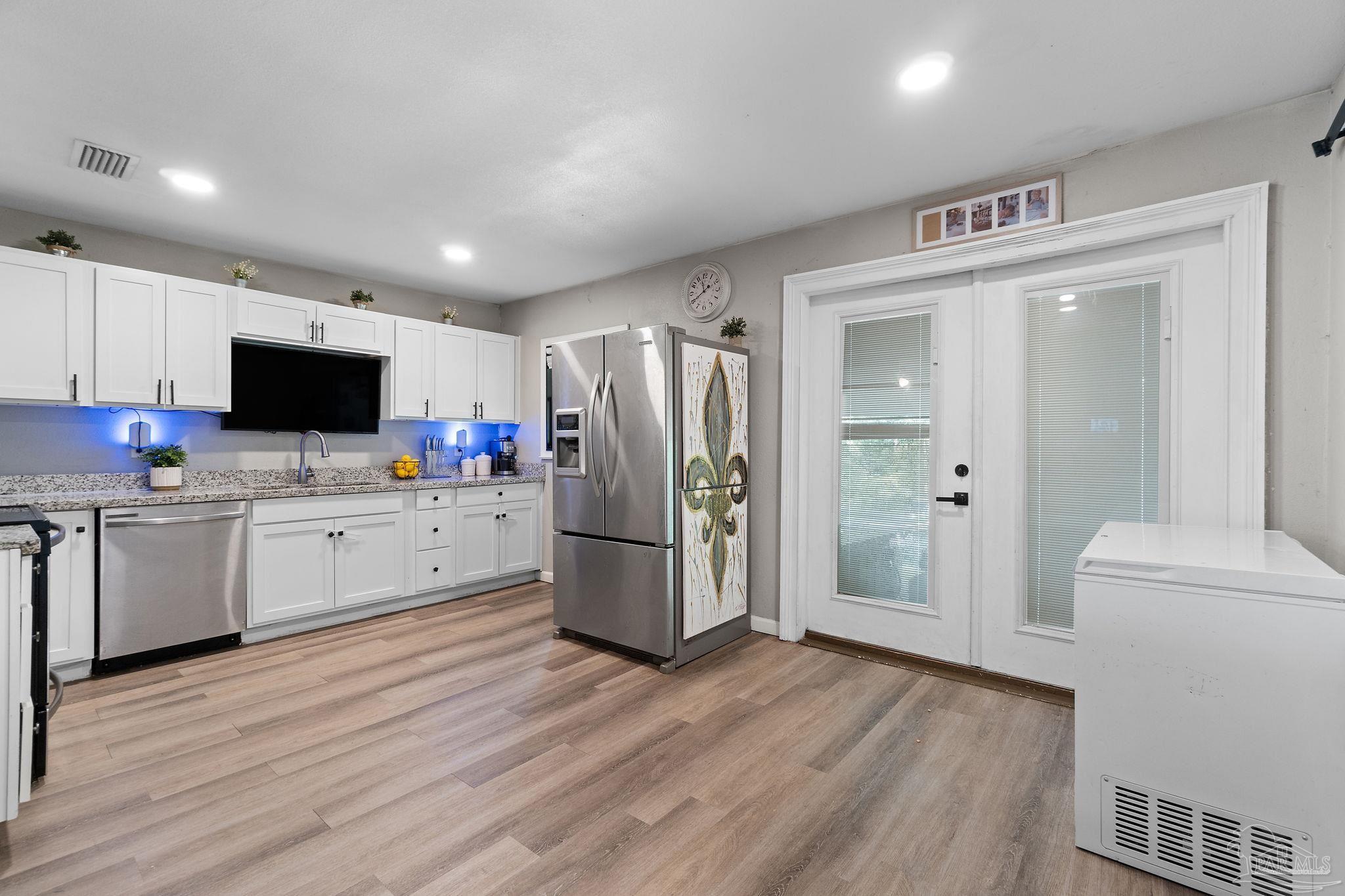 10610 Chemstrand Road Pensacola, FL 32514 - Photo 15 of 42 a kitchen with a refrigerator stove and wooden floor