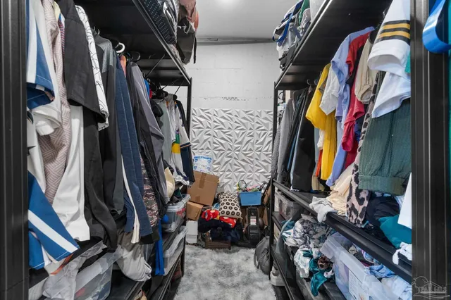 a view of walk in closet with clothes and shoes