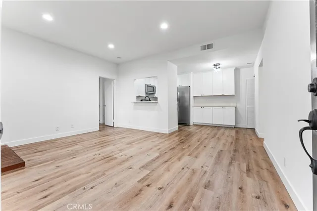 a view of empty room with wooden floor