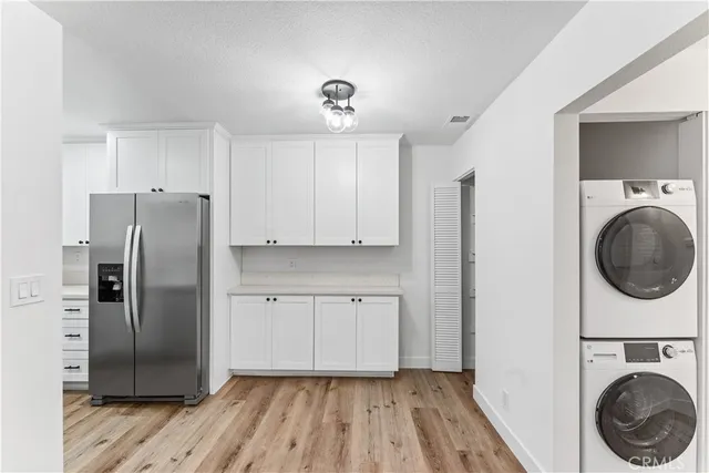 a kitchen with a refrigerator sink and cabinets