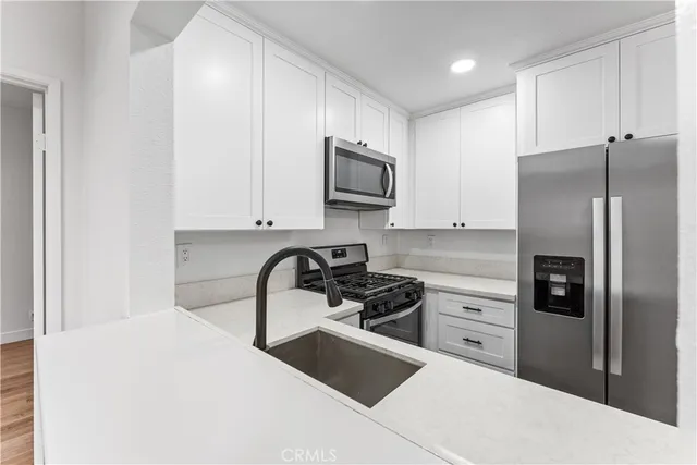 a kitchen with stainless steel appliances a refrigerator stove and microwave