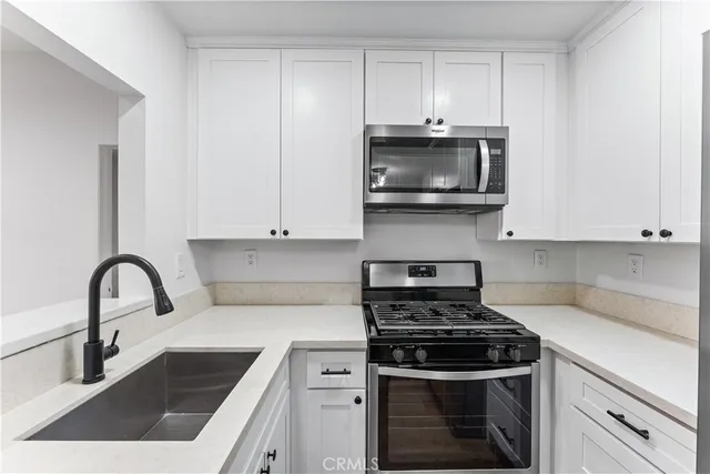 a kitchen with stainless steel appliances a stove a sink and a microwave