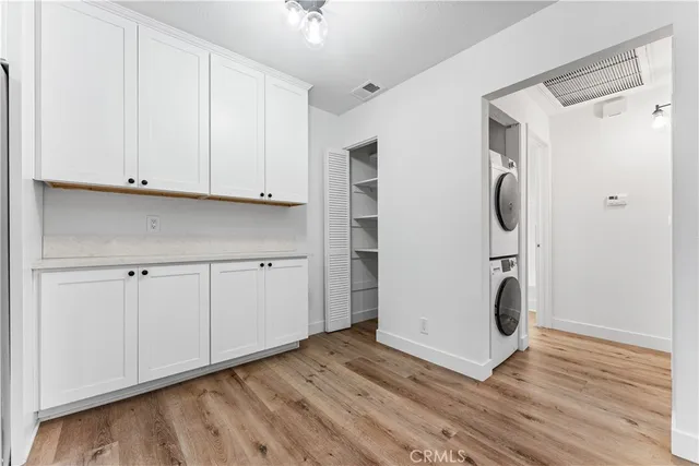 a view of an empty room with wooden floor and a cabinet