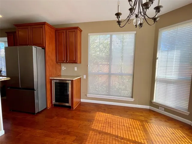 a kitchen with stainless steel appliances granite countertop a refrigerator a sink dishwasher and wooden cabinets