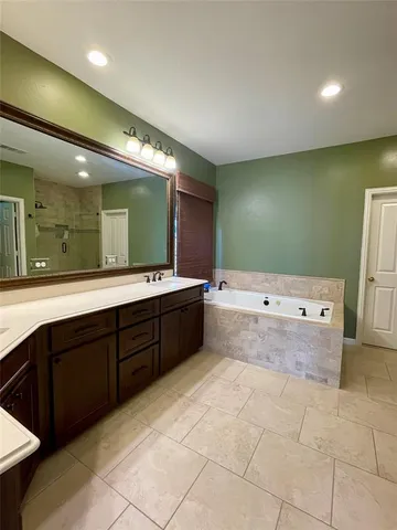 a bathroom with a sink mirror and a bathtub