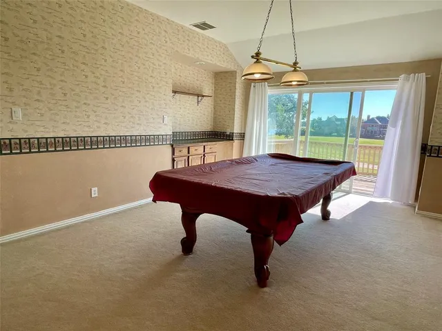 a room with pool table and windows