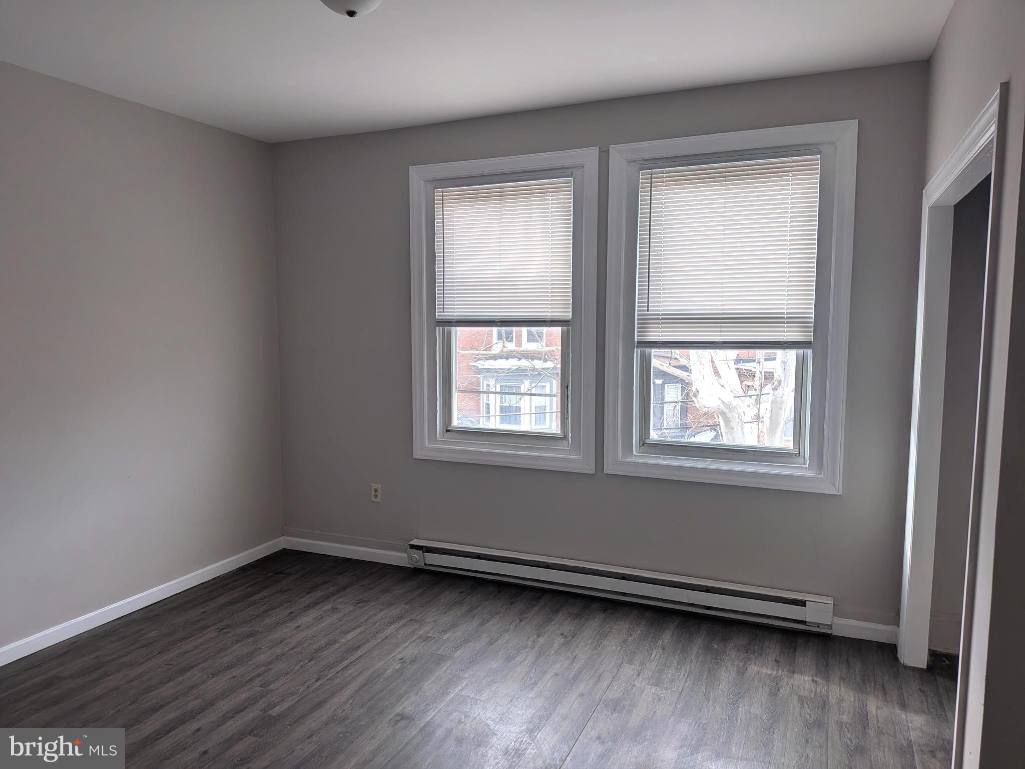 1343 West Pike Street, Unit 3 Philadelphia, PA 19140 - Photo 2 of 10 an empty room with wooden floor and windows