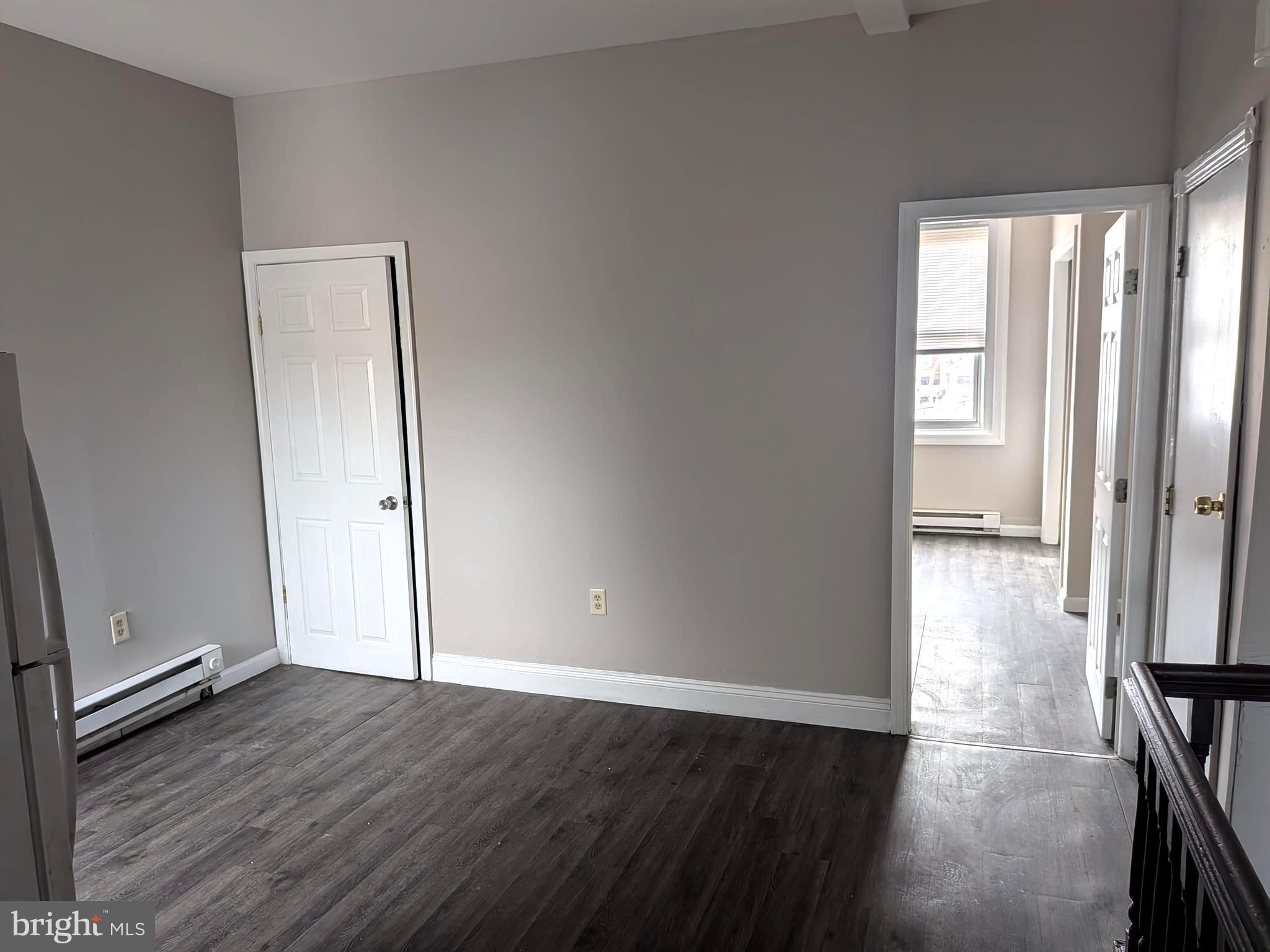 1343 West Pike Street, Unit 3 Philadelphia, PA 19140 - Photo 5 of 10 an empty room with wooden floor and windows