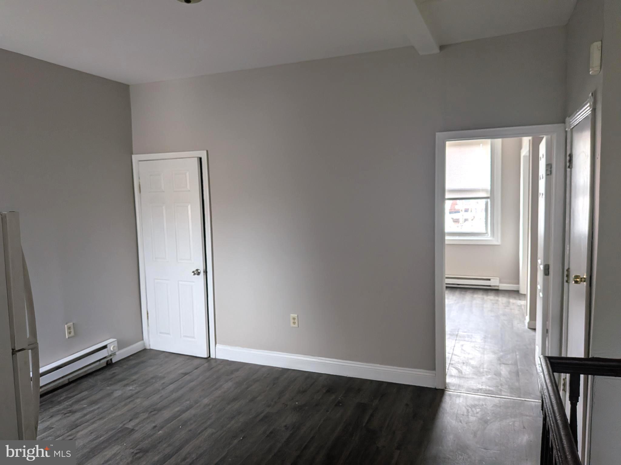 1343 West Pike Street, Unit 3 Philadelphia, PA 19140 - Photo 6 of 10 an empty room with wooden floor and a window