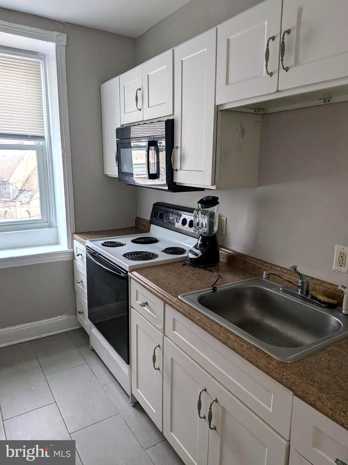 1343 West Pike Street, Unit 3 Philadelphia, PA 19140 - Photo 9 of 10 a kitchen with white cabinets and appliances