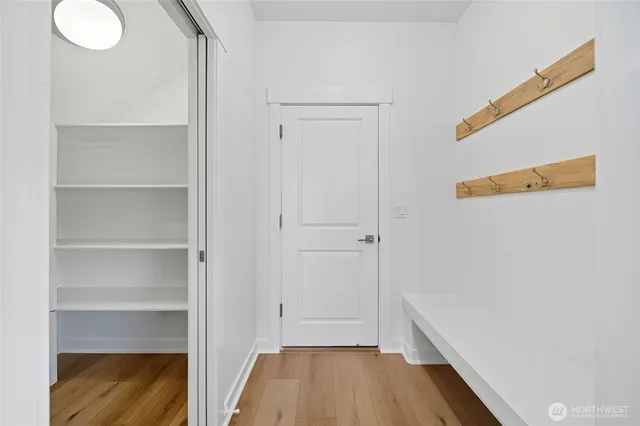 a view of walk in closet with wooden floor