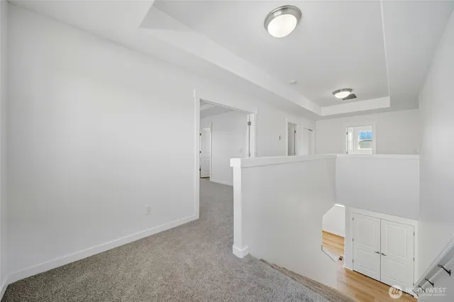 a view of a kitchen with refrigerator and white cabinets