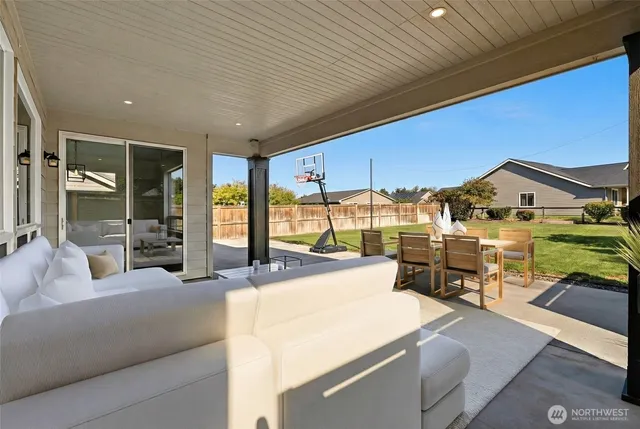 a living room with furniture a flat screen tv and large windows