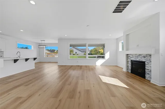 a view of an empty room with window and wooden floor