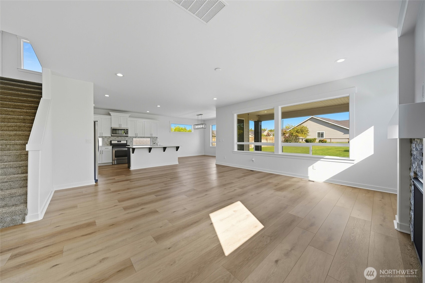 476 Reserve Way Walla Walla, WA 99362 - Photo 6 of 40 a view of open kitchen with wooden floor and a flat screen tv