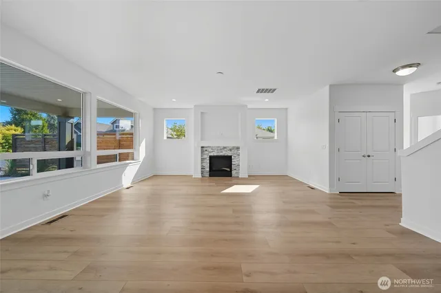 a view of empty room with a fireplace and window