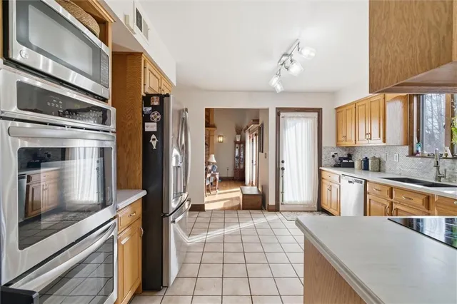 a kitchen with a refrigerator a stove top oven and cabinets