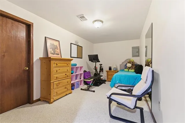 a view of a room with gym equipment and wooden floor