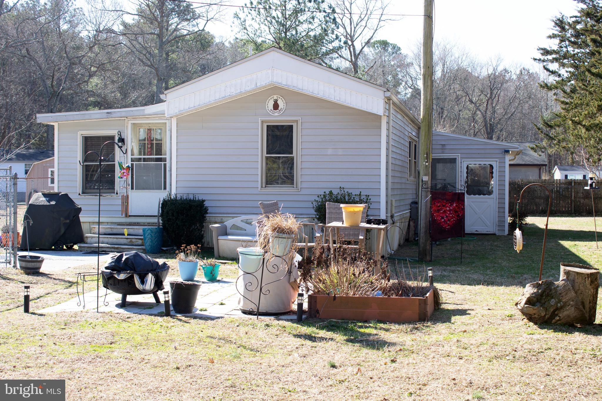 30780 Friendship Road Millsboro, DE 19966 - Photo 1 of 8 a view of a backyard with a patio and a fire pit