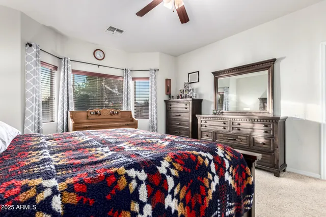 a bedroom with a bed and dresser with mirror