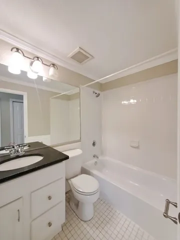 a bathroom with a granite countertop sink a toilet a mirror and shower
