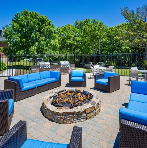 a view of a backyard with swimming pool and couches chairs