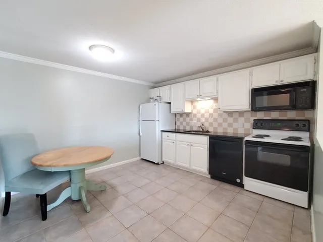 a kitchen with granite countertop a sink cabinets and stainless steel appliances