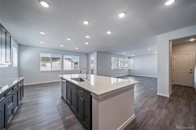 a kitchen with stainless steel appliances granite countertop a sink stove and wooden floor