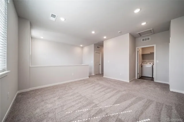 an empty room with closet and windows