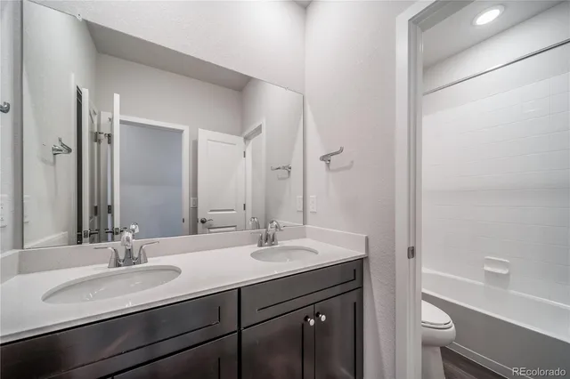 a bathroom with a double vanity sink toilet and a mirror
