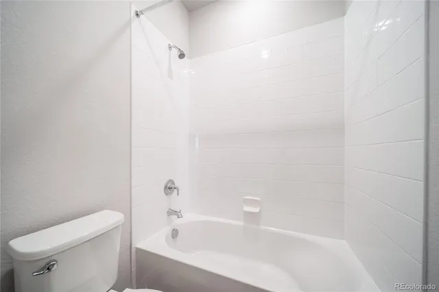 a white bath tub sitting next to a white toilet