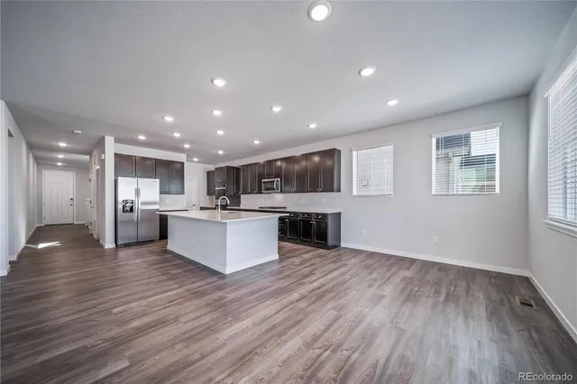a view of kitchen with kitchen island wooden floors appliances and center island