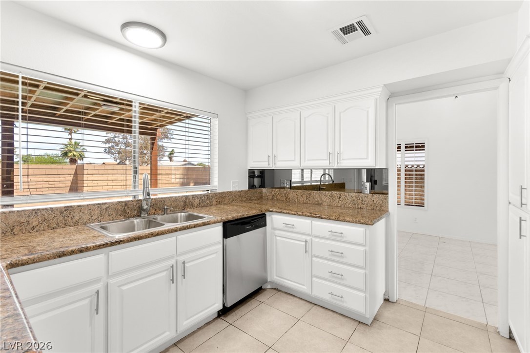 4430 Cranbrook Way Las Vegas, NV 89103 - Photo 12 of 50 A well-appointed kitchen features ample white cabinetry, granite counters, and integrated appliances.