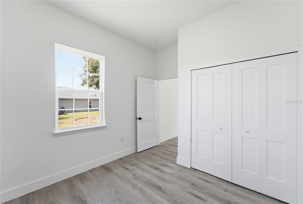 2600 Southwest 146th Pl Road Ocala, FL 34473 - Photo 16 of 40 a view of an empty room with wooden floor and a window