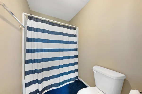 a white toilet sitting next to a shower curtain