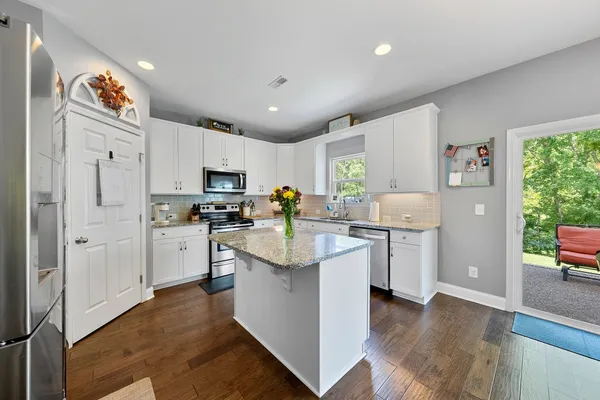 a kitchen with white cabinets and stainless steel appliances