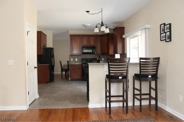 a kitchen with a chandelier stainless steel appliances and cabinets