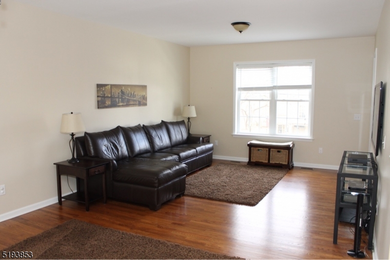 58 Main Street Peapack-Gladstone, NJ 07977 - Photo 3 of 6 a living room with furniture a wooden floor and a large window