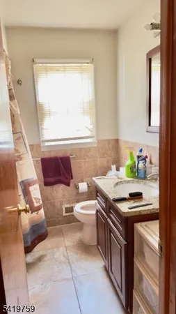 a bathroom with a granite countertop sink a toilet and a mirror