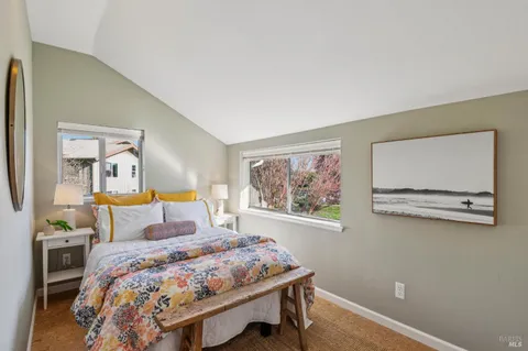 a bedroom with a bed a painting on the wall and a dresser