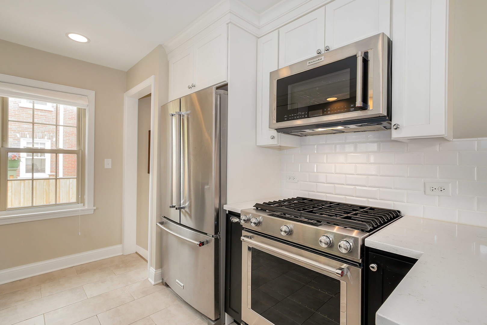 852 Spring Road Elmhurst, IL 60126 - Photo 8 of 24 a kitchen with stainless steel appliances a stove a microwave cabinets and a window