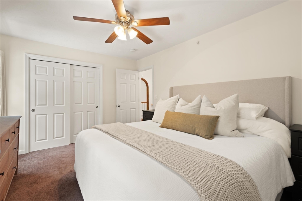 41 Boston Road, Unit 485 Billerica, MA 01862 - Photo 13 of 19 a bedroom with a large bed and a chandelier