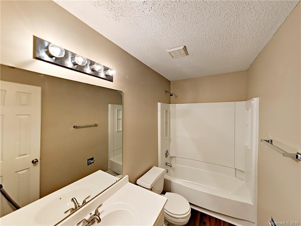 7315 Reedy Creek Road Charlotte, NC 28215 - Photo 16 of 18 a bathroom with a granite countertop sink a toilet and shower