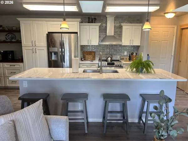 a kitchen with a table chairs refrigerator and microwave