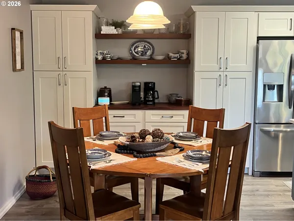 a kitchen with stainless steel appliances granite countertop a dining table and chairs