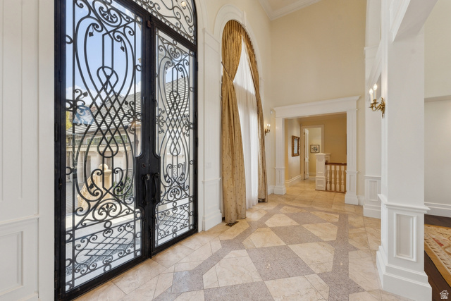 1714 Ridge Point Drive Bountiful, UT 84010 - Photo 16 of 132 Wrought iron and glass double entry doors, checkerboard pattern flooring, tall archway with drapery, and decorative wall sconces