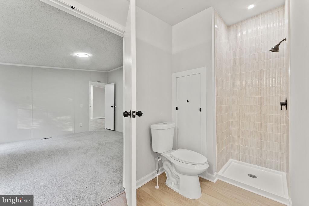 1109 Eastham Road Bumpass, VA 23024 - Photo 16 of 26 a bathroom with a toilet a sink and shower
